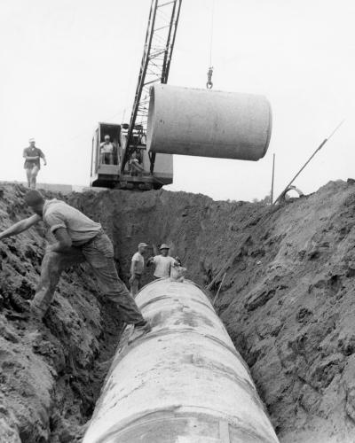 Workers laying sanitary sewer pipes.