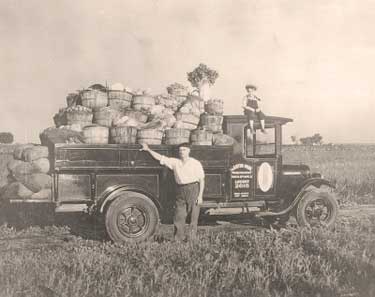 Old truck loaded with baskets of veggies.
